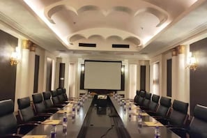 A conference room with a long table, chairs, a projector screen, and a whiteboard. - Xinzhou Haiwan Hotel (Shaoxing)