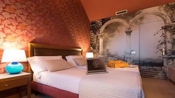 Une chambre d’hôtel avec un lit, deux lampes de chevet, un ordinateur portable et une fresque représentant une arche.