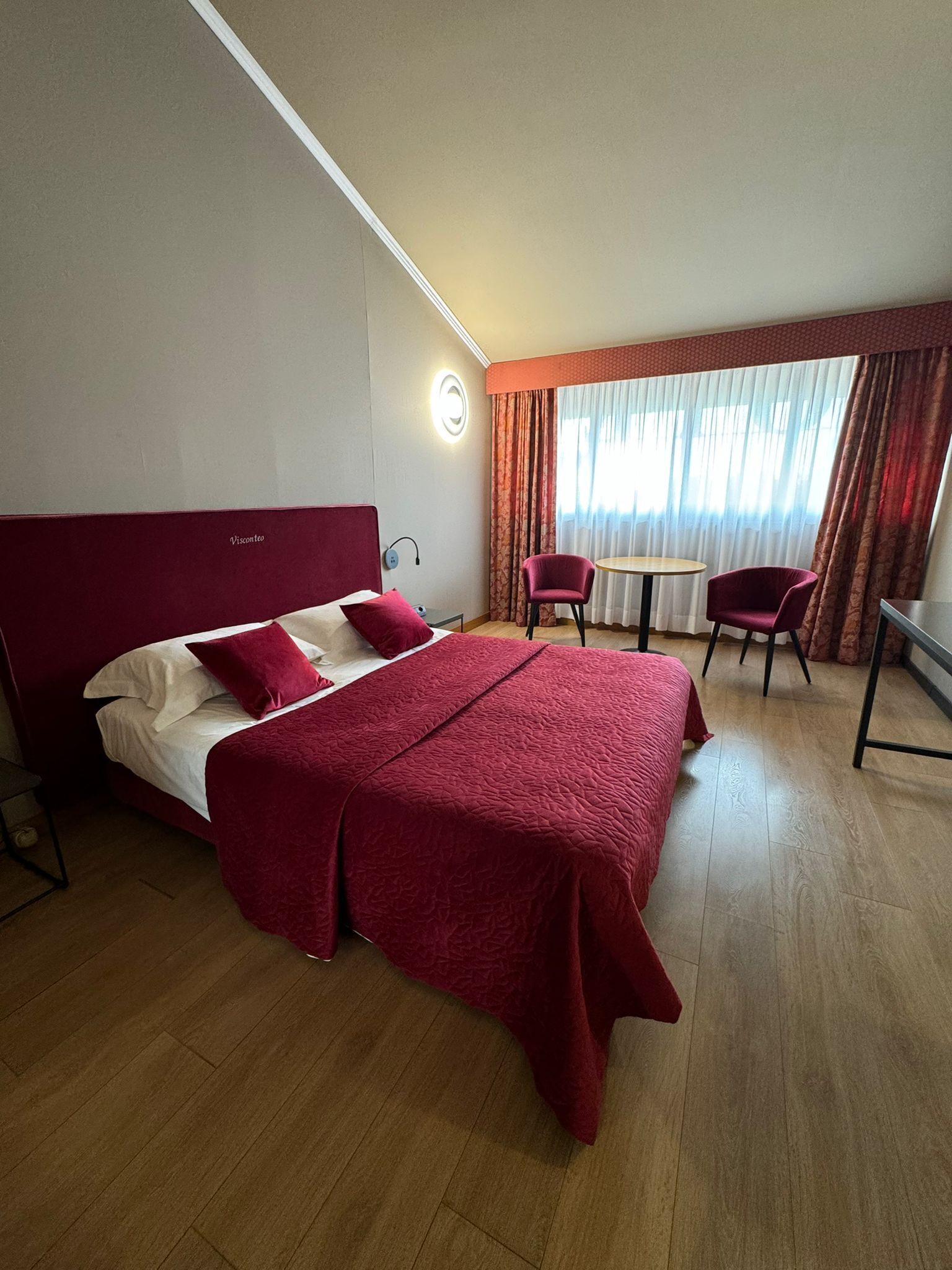 Une chambre d’hôtel avec un grand lit, un bureau et une chaise.