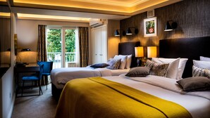 A hotel room with two beds, a desk with a chair, a window with curtains, and a balcony. - Roxford Lodge Hotel (Dublin)