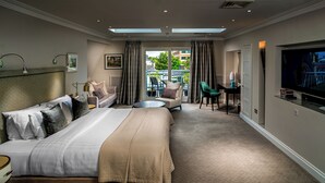 A hotel room with a large bed, a sofa, a desk, and a TV. - Roxford Lodge Hotel (Dublin)