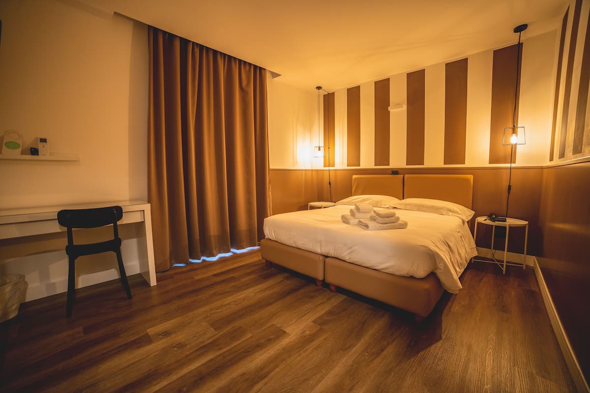 Een hotelkamer met een bed, een bureau en een stoel.