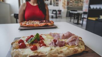 Eine Pizza mit verschiedenen Belägen auf einem Holzbrett.