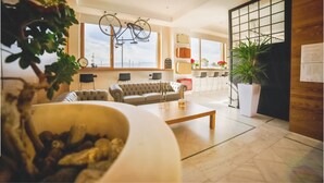 A modern living room with a sofa, coffee table, and potted plants.
