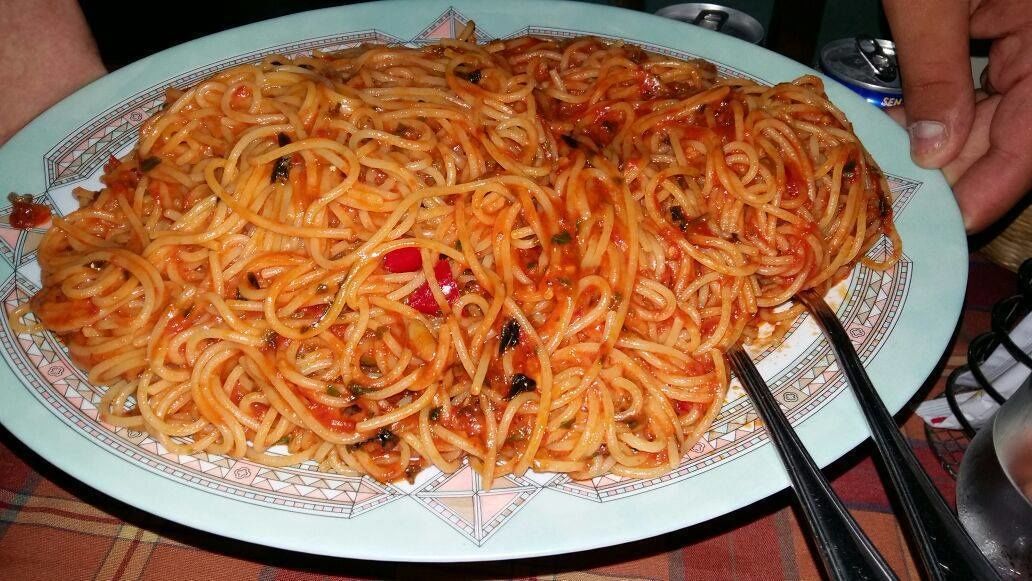 Un plato grande de espagueti con un borde decorado.
