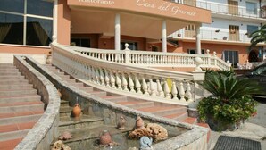 A hotel with a staircase leading to a covered area labeled "Hotel Ristorante" and "Casa del Gourmet." - Casa del Gourmet (Siderno)