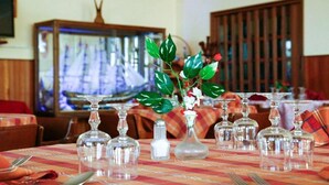 A dining table set with clear glassware and a vase with flowers. - Casa del Gourmet (Siderno)