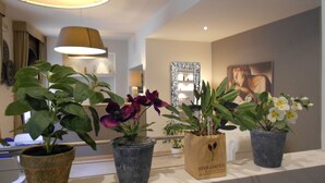 A room with a white reception desk, a mirror, and potted plants on a counter. - Hotel Ares (Milan)