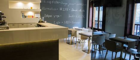 Un café moderne avec un menu écrit à la craie, des meubles en bois et un coin bar.