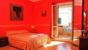 Un dormitorio con una cama, una mesita de noche, una ventana y una puerta que da a un balcón.
