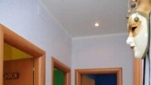 Un pasillo con puertas de madera y una pared azul.