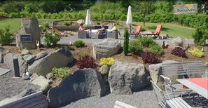 A garden area with outdoor seating, a sign for 'Zum Bockshahn', and a 'Saunagarten' sign. - Hotel und Landgasthof Zum Bockshahn (Spessart)