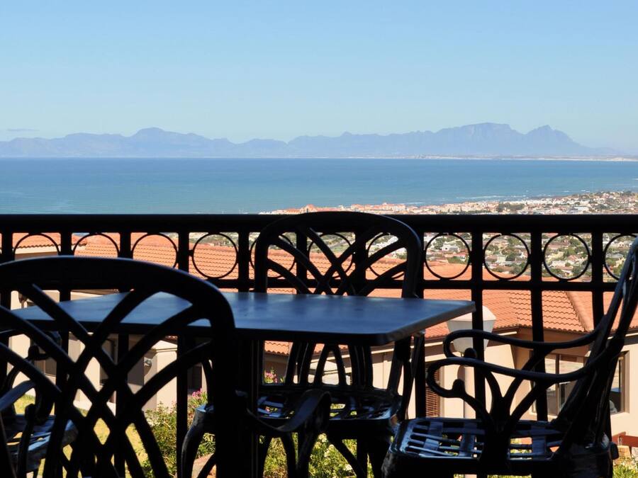 Un balcon avec vue sur la mer et les montagnes.