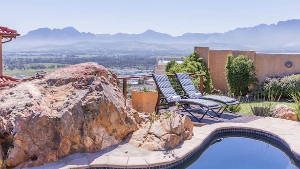 A pool area with lounge chairs and a view of mountains. - Blue Horizon Guest House (Cape Town)