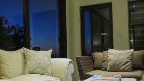 A living room with a sofa, armchairs, and a coffee table with magazines. - Blue Horizon Guest House (Cape Town)