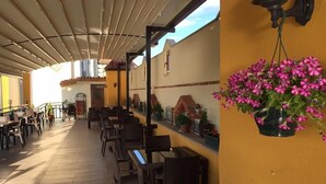An outdoor patio with tables and chairs, a hanging flower pot, and a wall-mounted light fixture. - Ulasan Hotel (Golbasi)