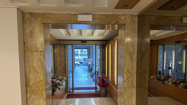 A marble-floored hallway with a glass door leading outside. - Hotel Città Studi (Milan)