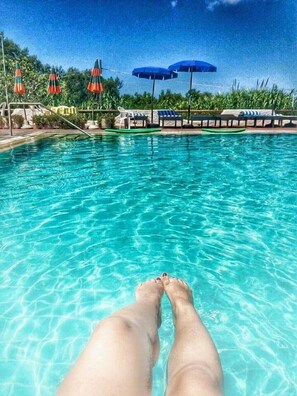 Een buitenzwembad en ligstoelen