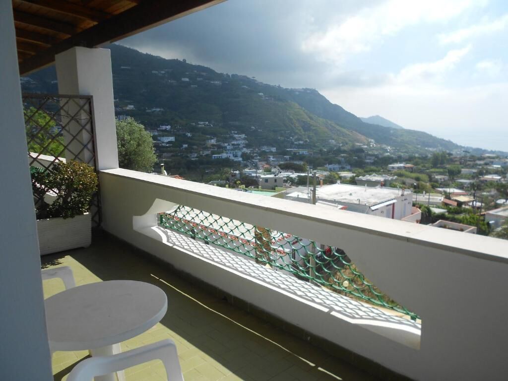 A balcony with a view of a town and mountains.