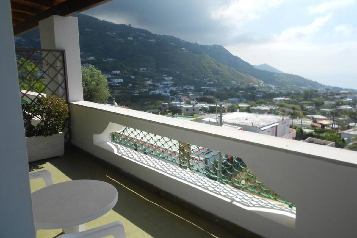 A balcony with a view of a town and mountains.