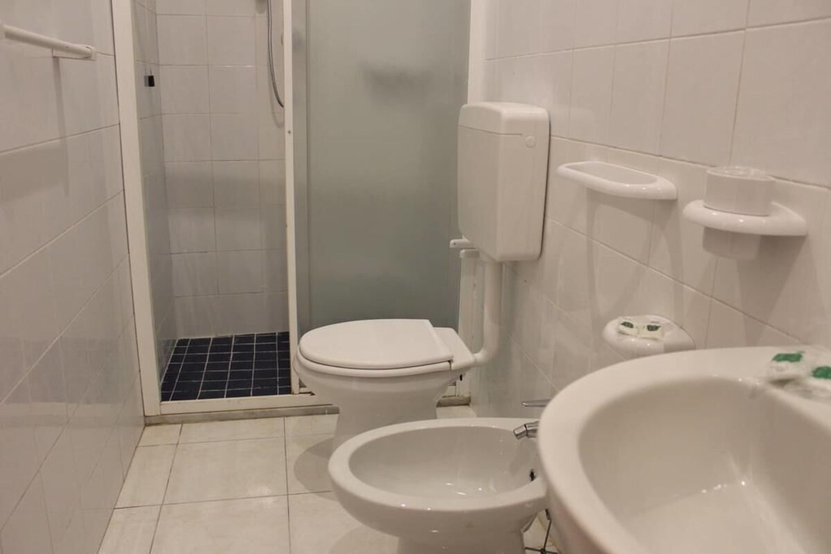 Un baño con inodoro, bidé y cabina de ducha.