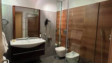 Un bagno moderno con doccia vetrata, un mobile lavabo e un WC.