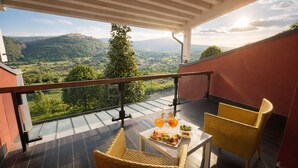 A balcony with a table set for two, overlooking a scenic landscape. - Hotel Bouganville (Picerno)