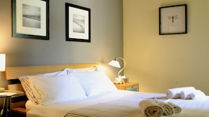 A hotel room with a neatly made bed, a bedside lamp, and framed pictures on the wall. - Casa Barbero Charme & Rooms (Catania)