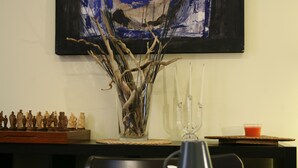 A dining table with a chess set, a vase with branches, and a glass pitcher. - Casa Barbero Charme & Rooms (Catania)