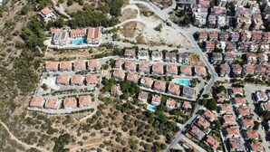 An aerial view of a residential area with multiple apartment buildings, roads, and green spaces. - Asia Apart Hotel (Kusadasi)
