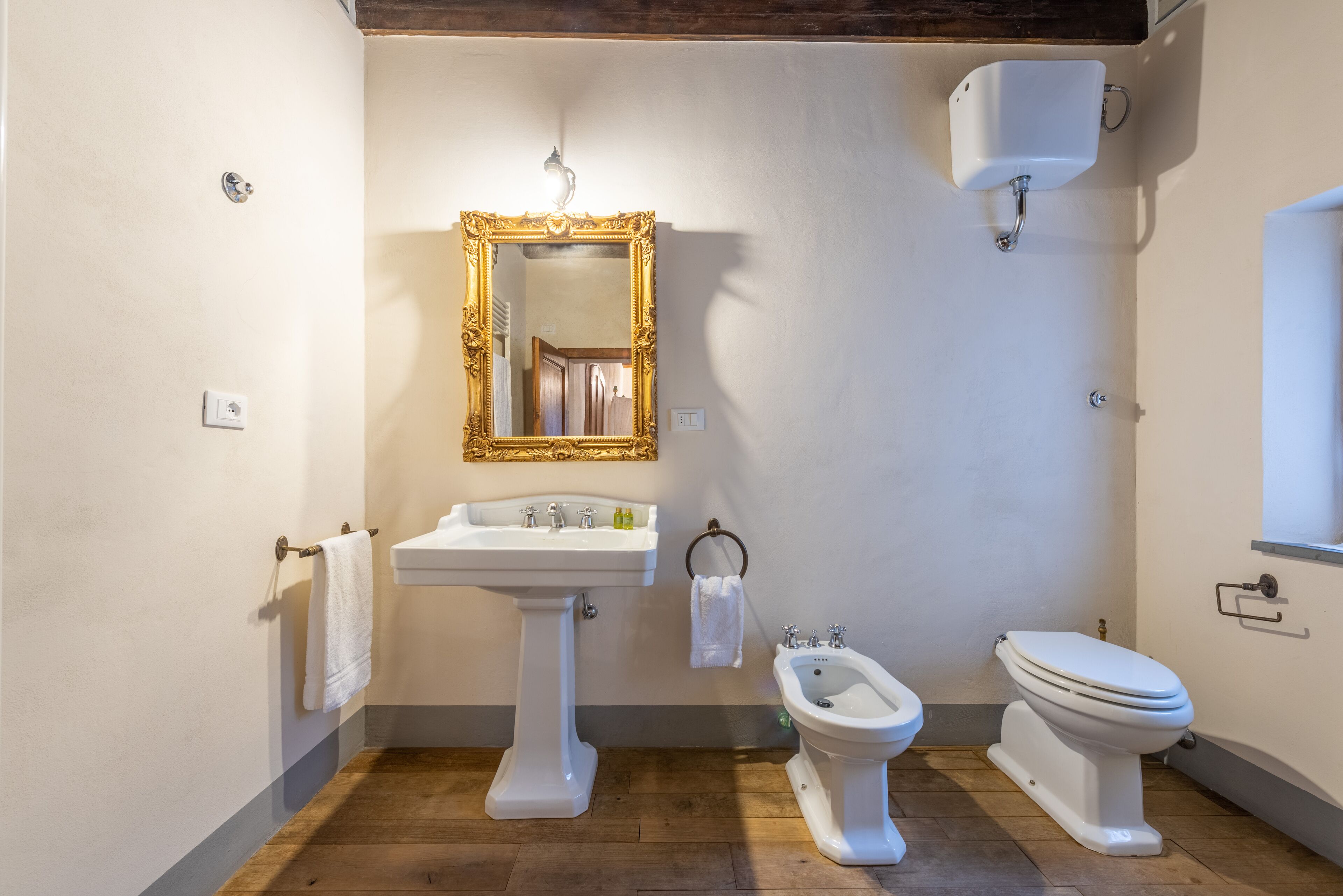 Une salle de bain avec un lavabo sur colonne, un bidet et des toilettes.