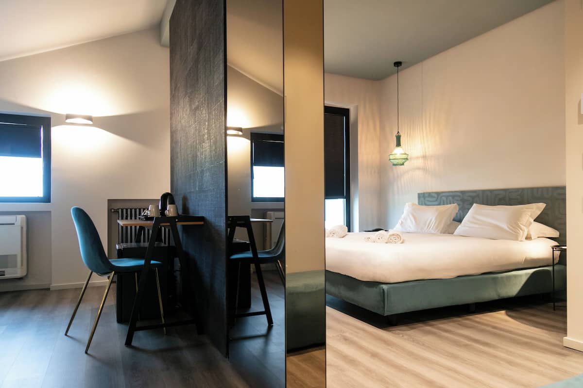 A modern room with a bed, a desk, and chairs.
