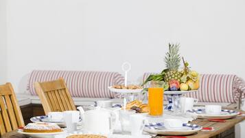 A breakfast table set with plates, cups, and a fruit bowl.