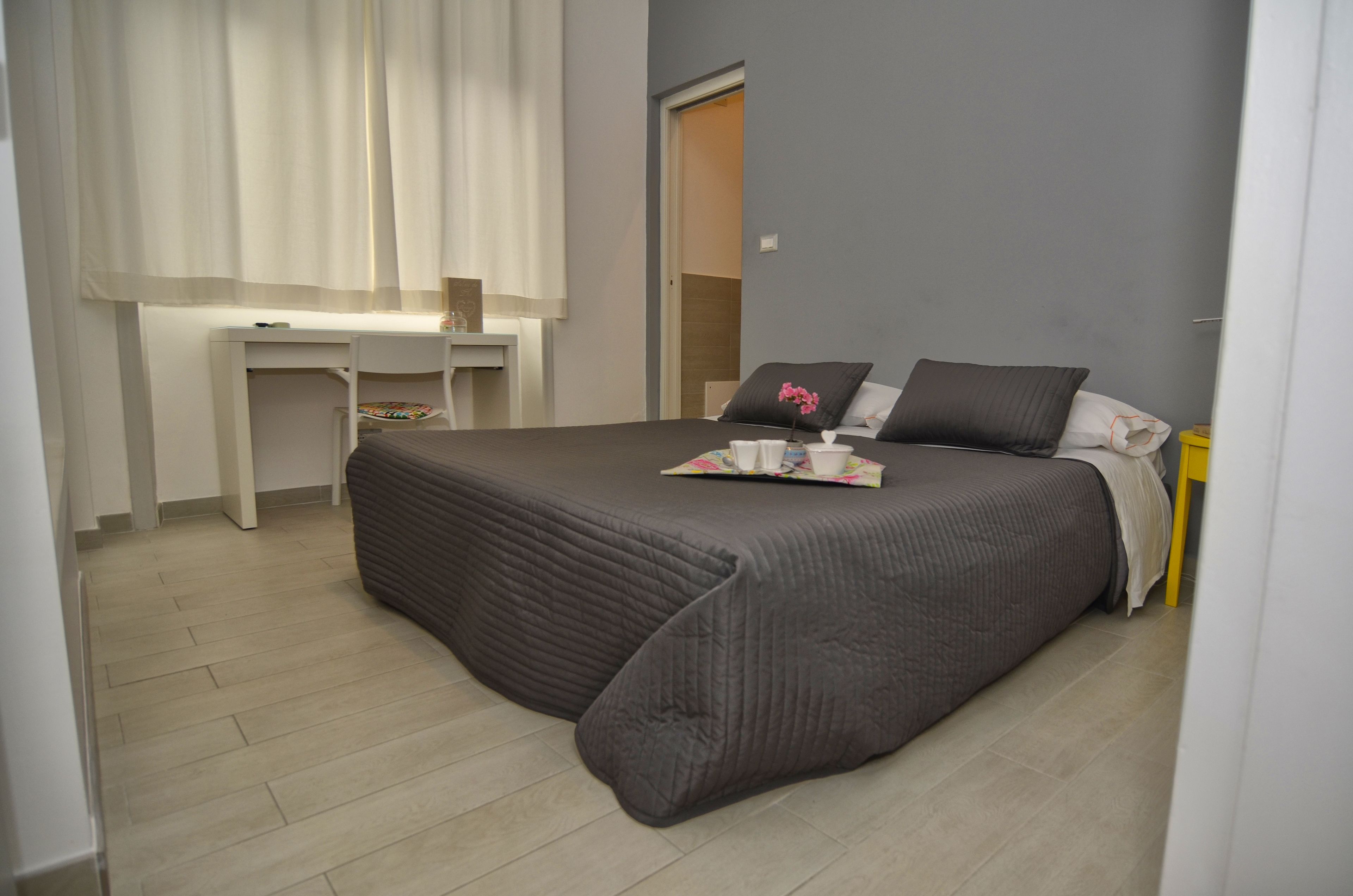 Un dormitorio con una cama, un escritorio y una silla.