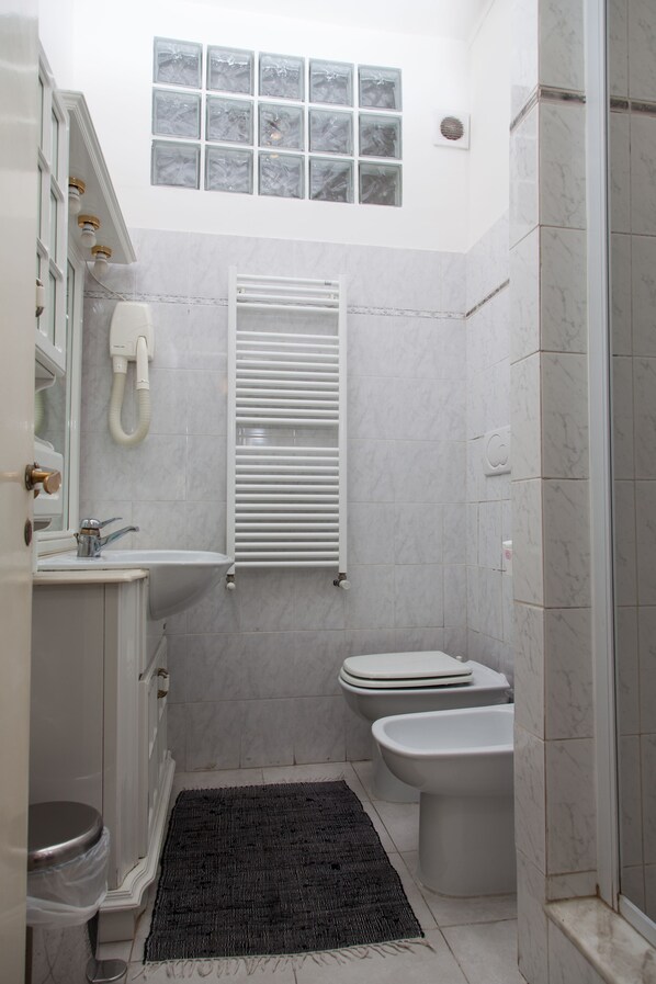 A compact bathroom with a toilet, bidet, and a shower area. - B&B Santa Croce (Rome)
