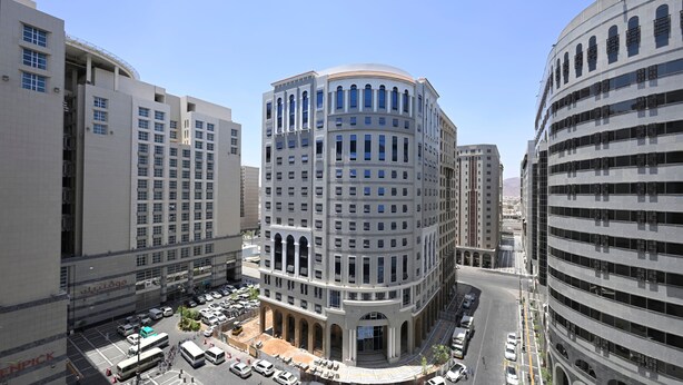 A multi-story building with a central courtyard, surrounded by other high-rise buildings. - Intercontinental Madinah - Dar Al Iman by IHG (Madinah)