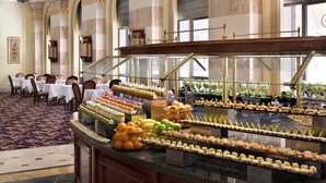 A buffet with various desserts and fruits, marble walls, and a chandelier. - Intercontinental Madinah - Dar Al Iman by IHG (Madinah)