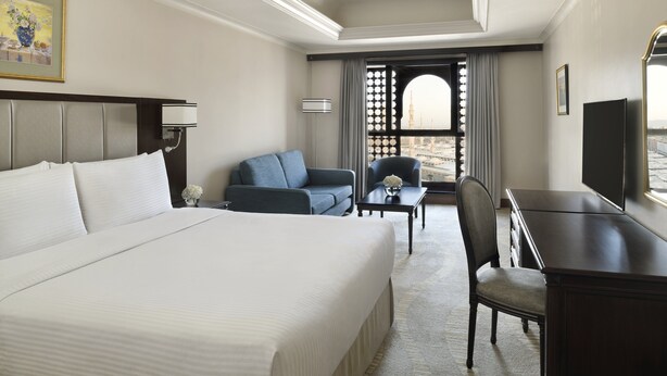 A hotel room with a large bed, a sofa, a desk, and a TV. - Intercontinental Madinah - Dar Al Iman by IHG (Madinah)