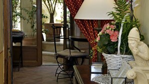 A room with a wooden desk, a chair, a lamp, a white orchid, a statue, and a wicker basket. - Un Mas en Ville (Marseille)