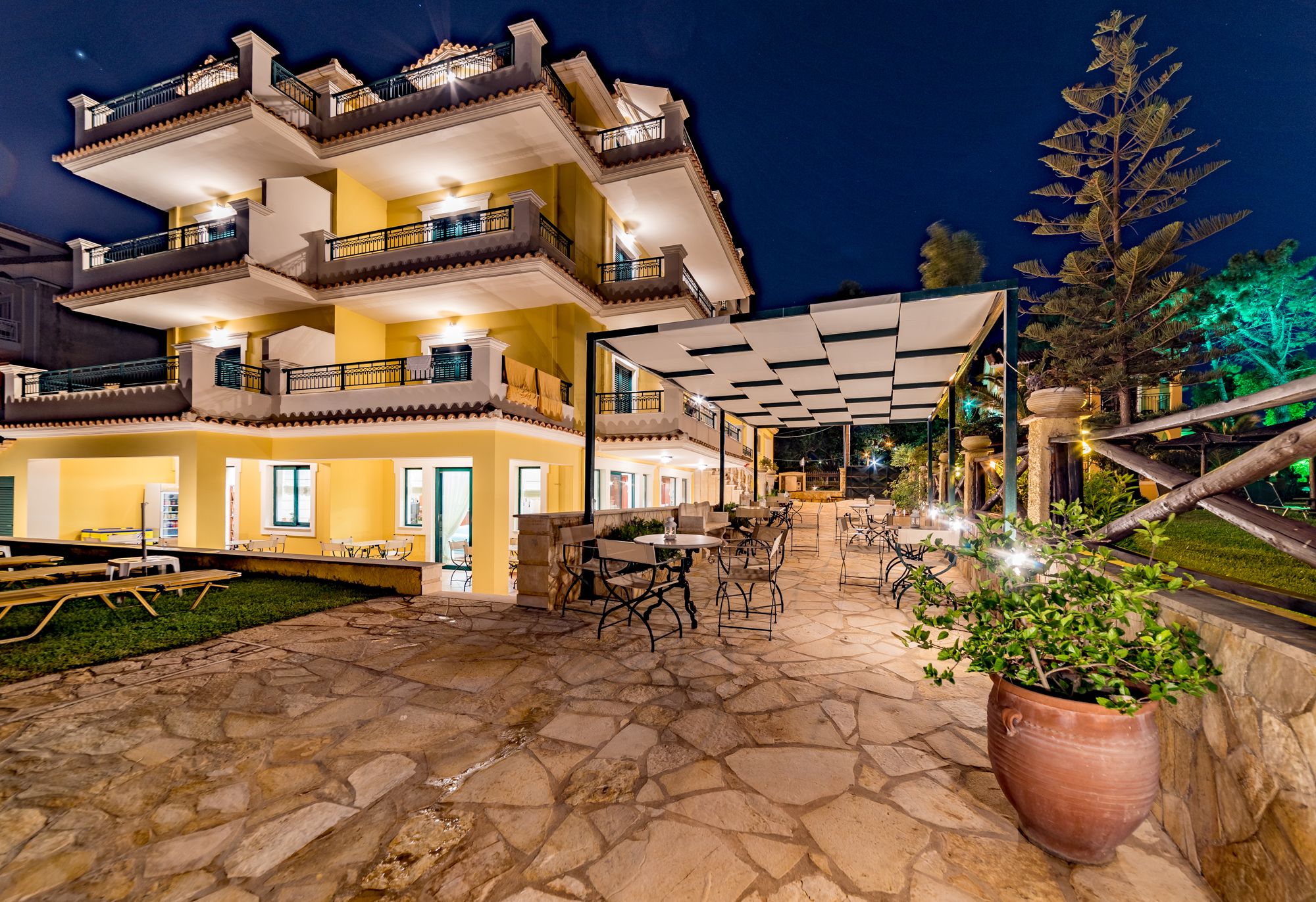 A multi-story building with outdoor seating and a covered patio area.