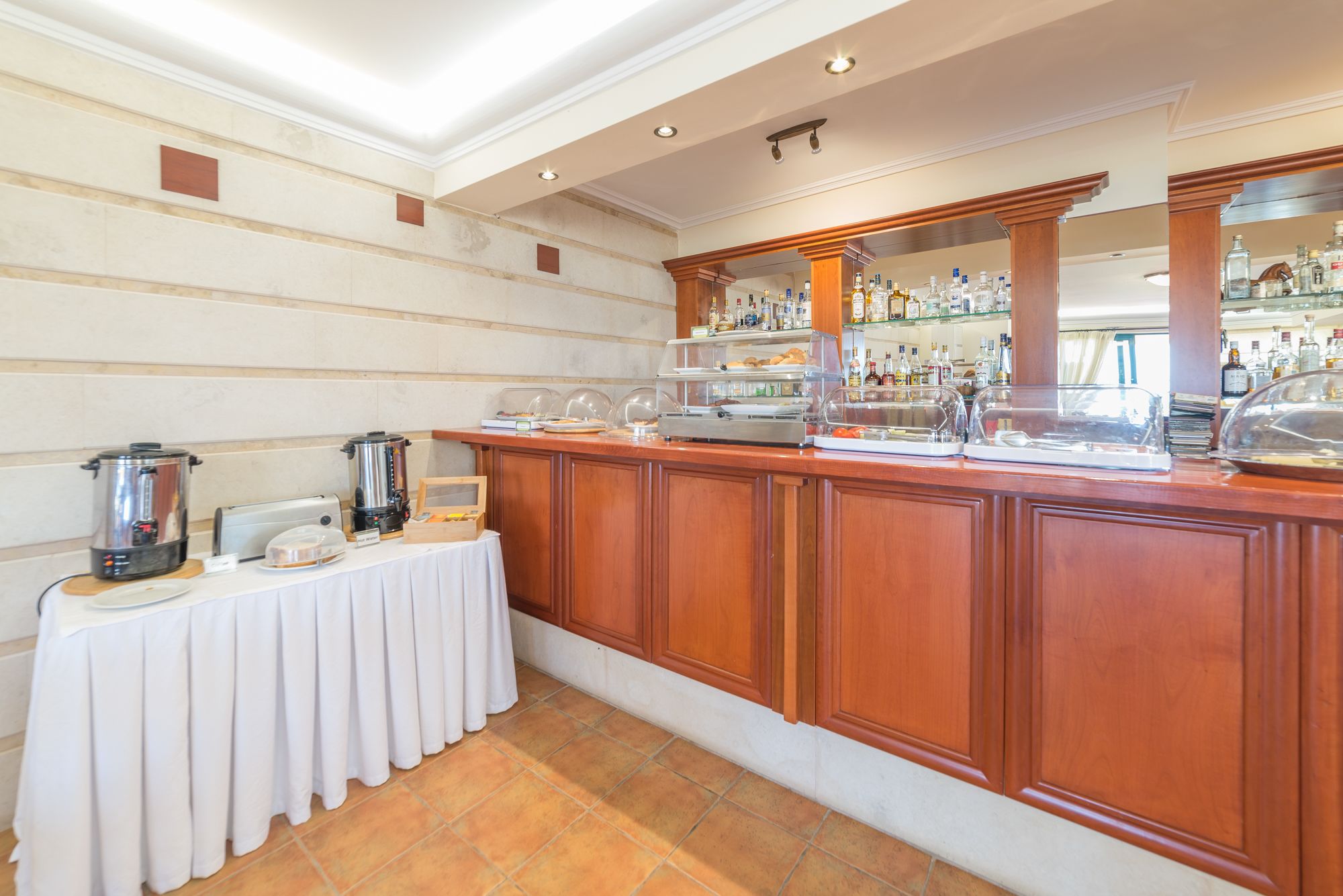 A buffet setup with a coffee maker, toaster, and a variety of food items on a table.