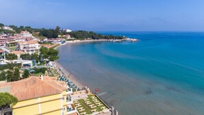 Un hotel frente al mar con vistas a la playa, varias habitaciones y zona de piscina.