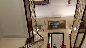 A grand staircase with red carpeted steps, wooden balusters, and a handrail. - Sol da Nave (Porto)