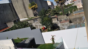 A modern building with a flat roof, a small garden area, and a visible staircase. - Sol da Nave (Porto)