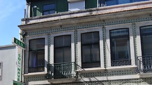 A multi-story building with a ground-floor entrance, large windows, and a balcony. - Sol da Nave (Porto)