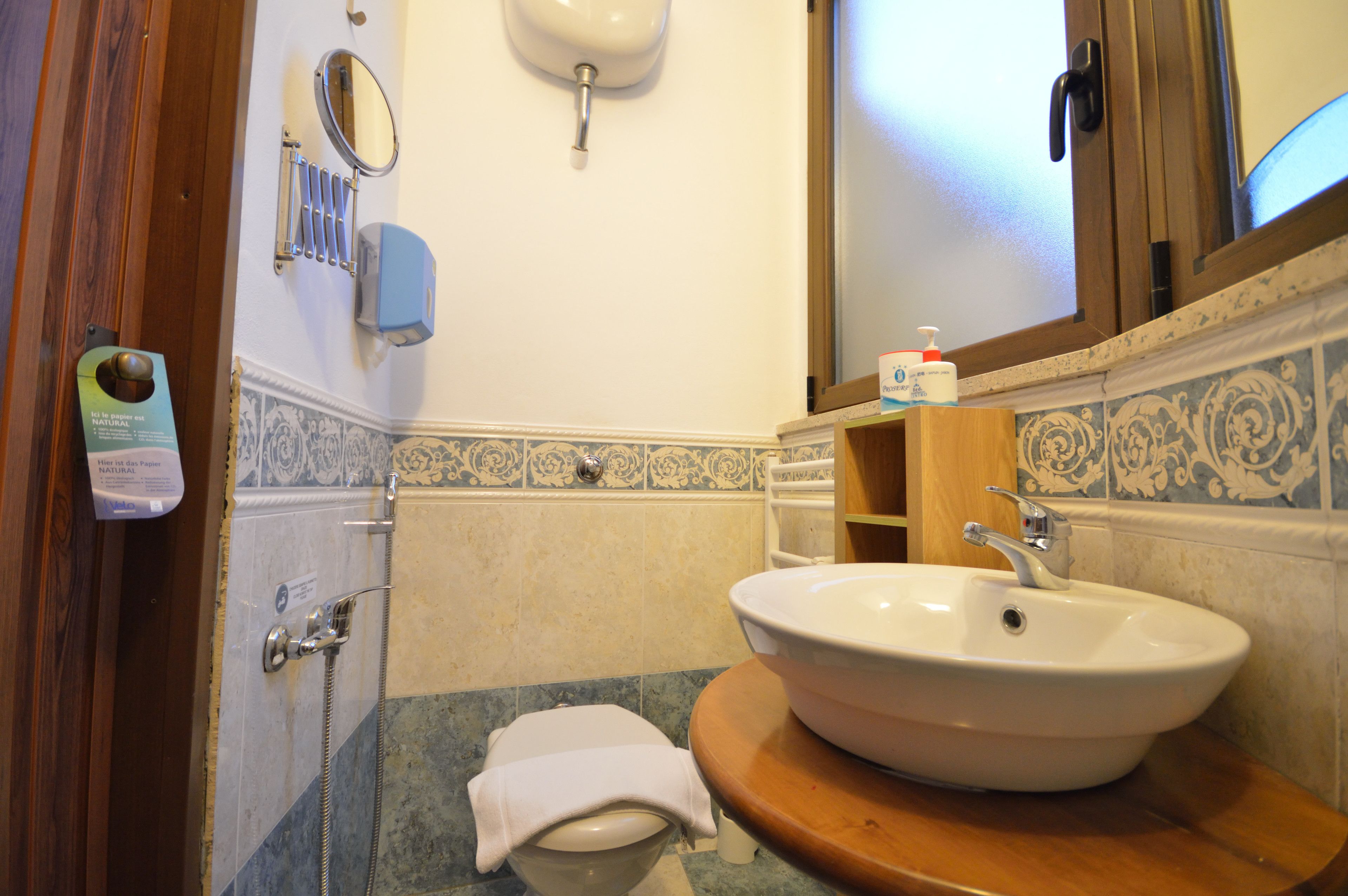 A bathroom with a sink, mirror, towel, and toiletries.