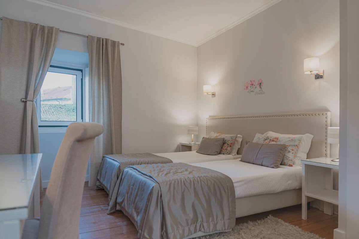 Ein Schlafzimmer mit zwei Betten, einem Schreibtisch und einem Stuhl.