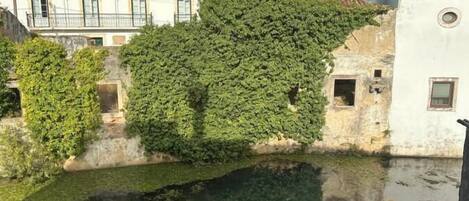Vista de un patio con fuente, rodeado de edificios con tejados rojos y paredes blancas.