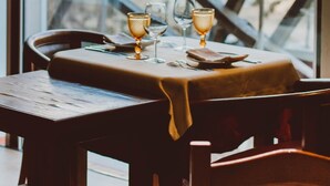 A table set for two with glasses and a lamp, overlooking a large metal structure. - Hotel Casa da Nora (Leiria)