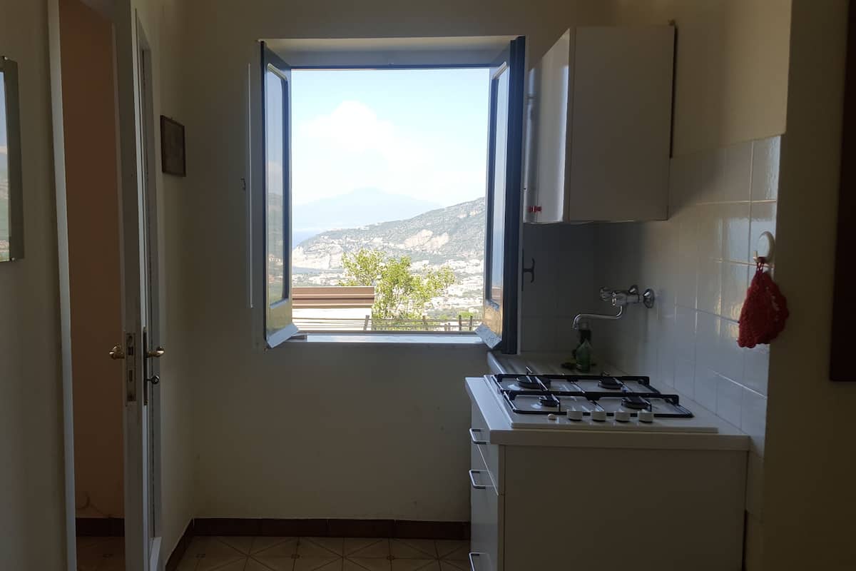 Una cocina con ventana, estufa y armarios.